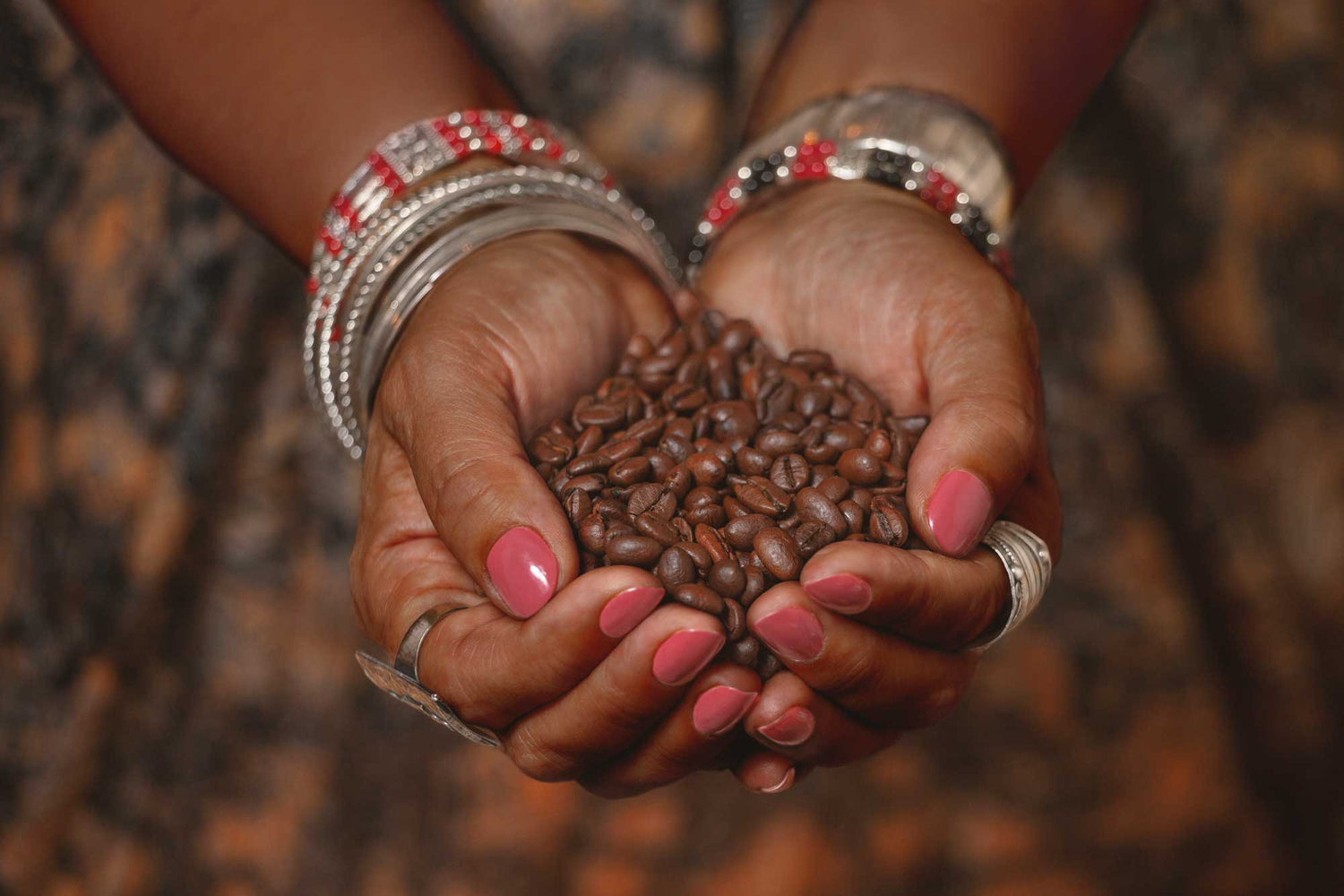 Womans hands holding roasted coffee beans